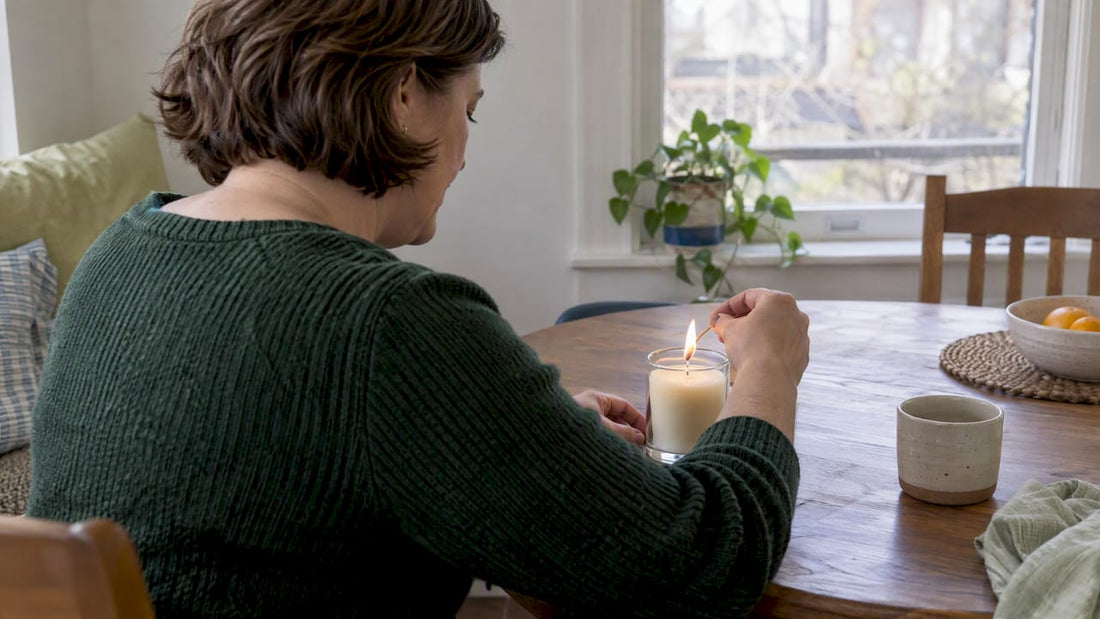 Woman lighting a candle at home