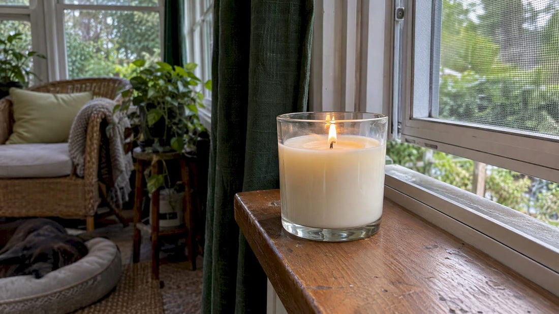 Soy candle burning beside an open window